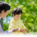 子供が両親にお花を渡す様子